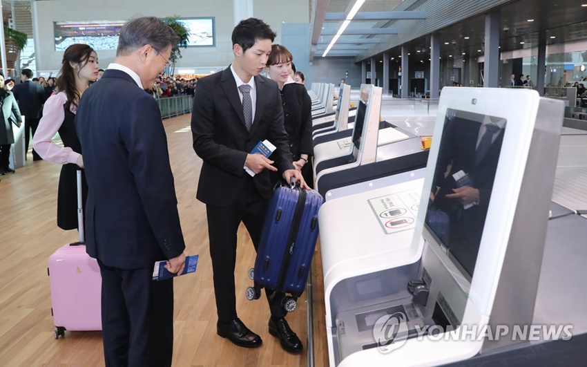 韓國總統文在寅、平昌冬奧會宣傳大使金妍兒、仁川機場宣傳大使宋仲基體驗自助托運行李，感受智能機場便利。