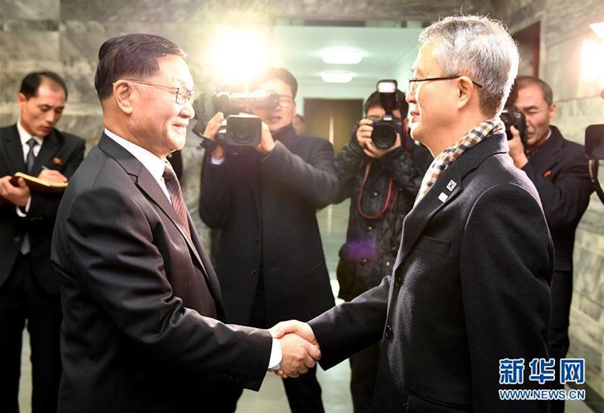 1月15日，在板門店朝方一側的統一閣，韓方代表團團長李宇盛（右）與朝方代表團團長權赫奉握手。新華社發（韓國統一部提供）