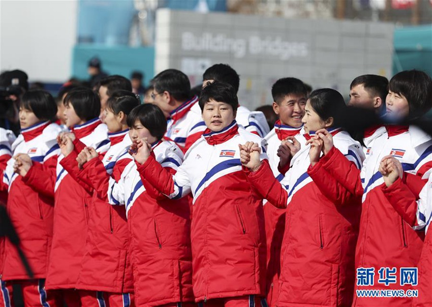 2月8日，朝鮮體育代表團成員在升旗儀式上手拉手。新華社記者韓岩攝