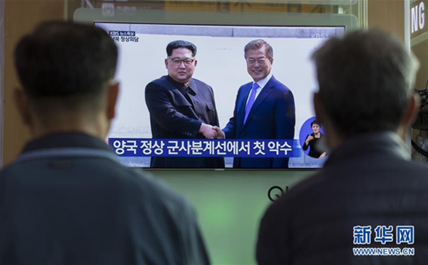 4月27日，在韓國首爾火車站，人們觀看韓朝首腦會晤的電視畫面。新華社發（李相浩攝）