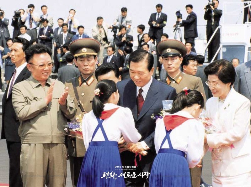2000年6月13日，時任韓國總統金大中從朝鮮小朋友手中接過鮮花。（圖片來自2018年朝韓首腦會晤網站）