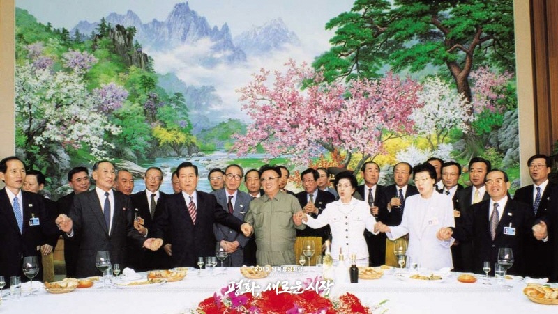 2000年6月15日，時任朝鮮最高領導人金正日（前排左四）、時任韓國總統金大中（前排左三）與雙方代表團合唱《我們的願望》。（圖片來自2018年朝韓首腦會晤網站）