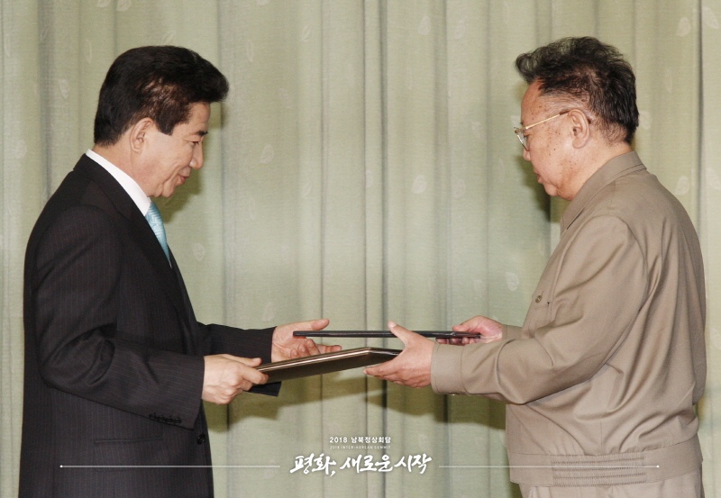 2007年10月4日，在朝鮮平壤百花園迎賓館，時任朝鮮最高領導人金正日（右）與時任韓國總統盧武鉉簽署並交換《北南關系發展與和平繁榮宣言》。（圖片來自2018年朝韓首腦會晤網站）