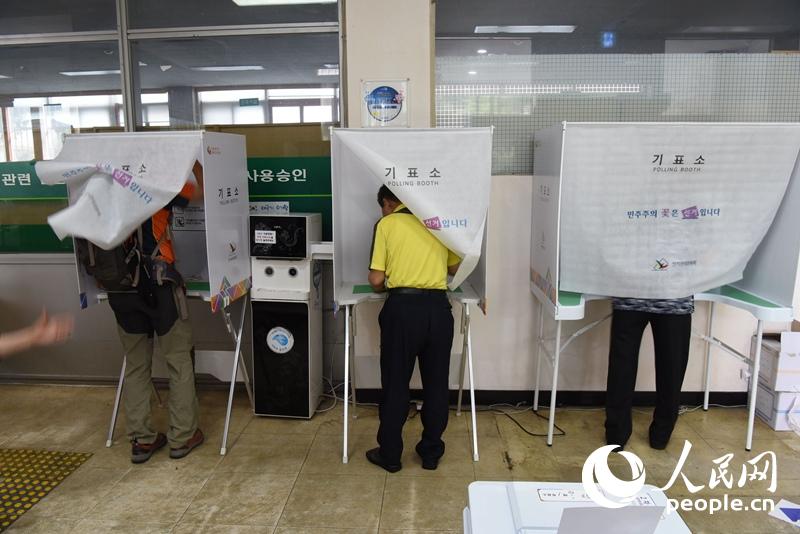 填写选票的韩国民众 裴��基摄