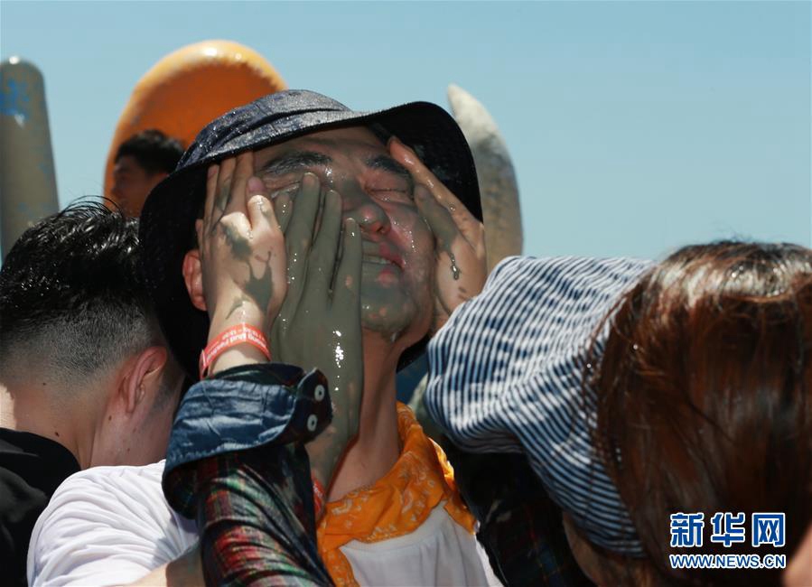 7月14日，游客在韓國保寧市舉行的保寧泥漿節上往臉上涂抹泥漿。新華社記者 王婧嬙 攝