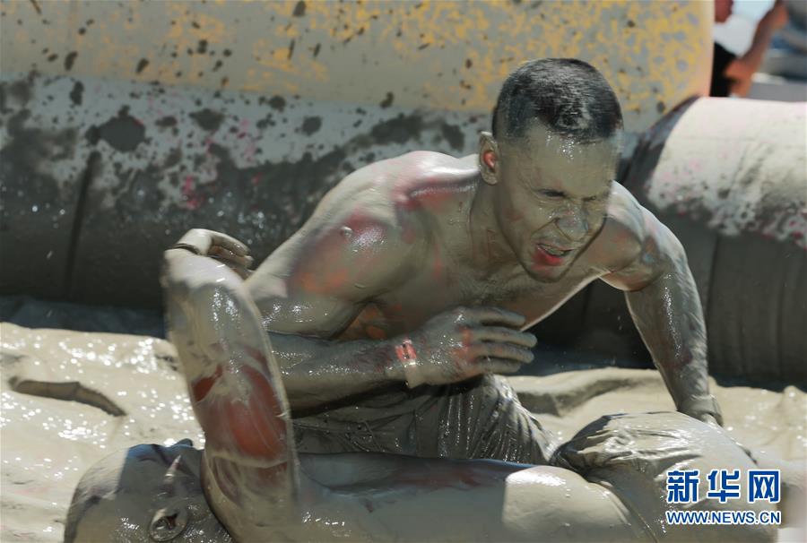 7月14日，游客在韓國保寧市舉行的保寧泥漿節上體驗泥漿摔跤。新華社記者 王婧嬙 攝
