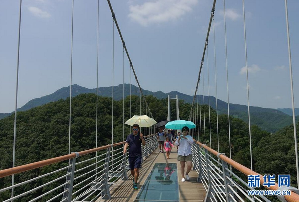 8月2日，游客撐傘游覽位於韓國京畿道抱川市的“天空之橋”。 近日韓國持續高溫天氣，多地刷新高溫紀錄。 新華社記者王婧嬙攝