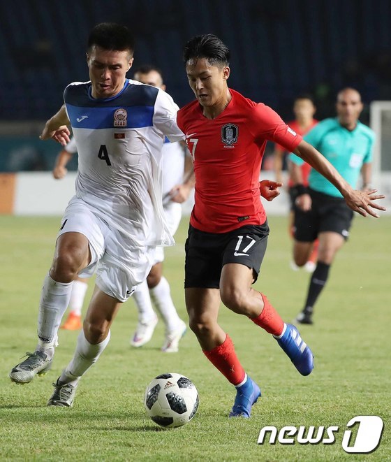 8月20日，在第18屆亞運會足球男子E組末輪的比賽賽場上，李承宇（右）正在帶球。
