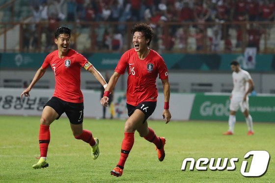 8月23日晚上，在印度尼西亞雅加達亞運會男足1/8決賽中，孫興民與黃義助（右）在比賽中慶祝勝利。