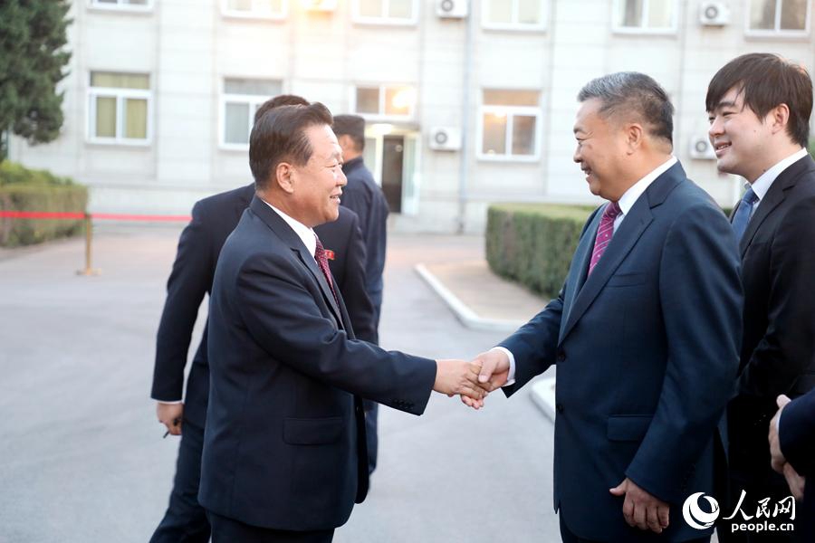 中國駐朝鮮大使李進軍（右）歡迎朝鮮勞動黨中央政治局常委、國務委員會副委員長崔龍海出席國慶69周年招待會。