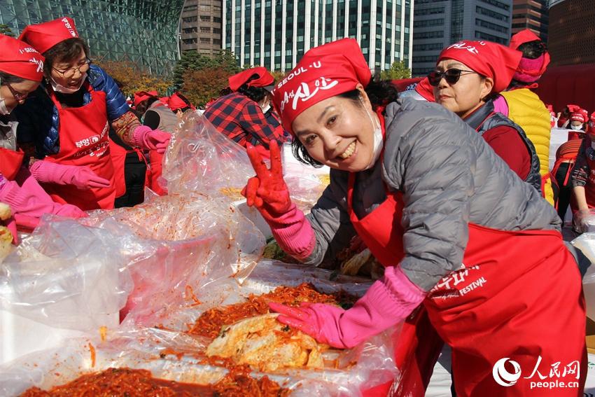 做完泡菜的韓國民眾向鏡頭擺出了勝利的手勢。 陳尚文攝