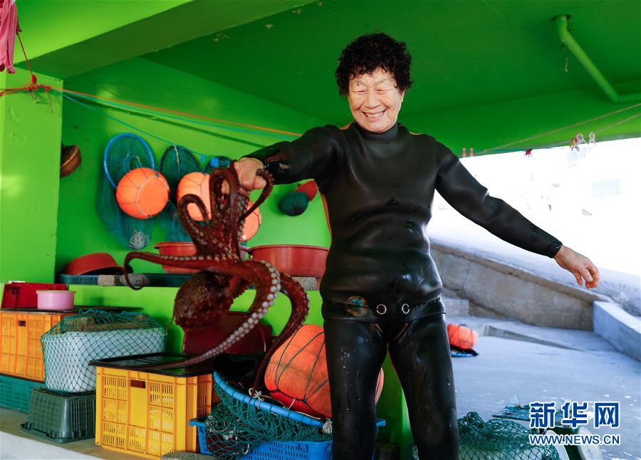 11月23日，一名海女在韓國濟州島一處海岸附近展示她的收獲。新華社記者 王婧嬙 攝