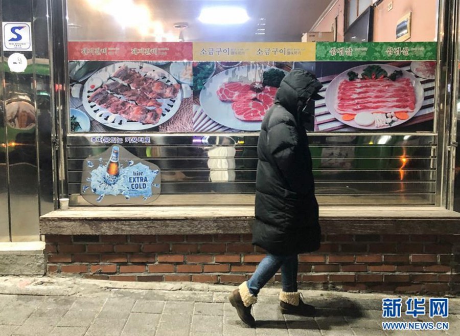 12月28日，一名行人走过韩国首尔街头。 新华社记者 王婧嫱 摄
