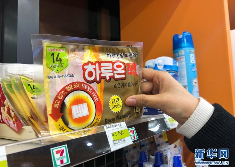 12月28日，一名顾客在韩国首尔的一家便利店购买暖宝宝。 新华社记者 王婧嫱 摄