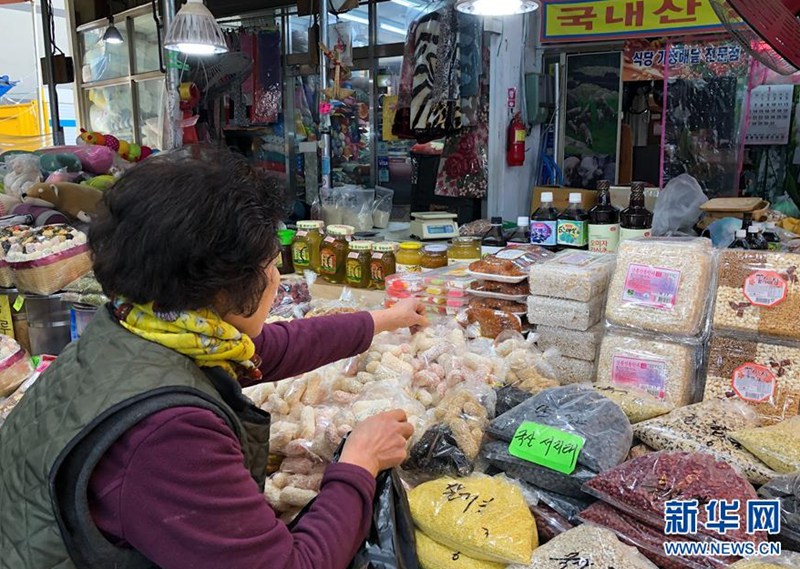 1月29日，一名女子在韓國首爾的靈泉傳統市場挑選韓國傳統糕點。新華社記者王婧嬙攝