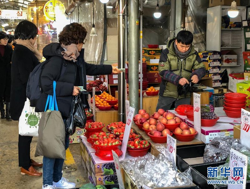 1月29日，人們在韓國首爾的靈泉傳統市場購買水果。新華社記者王婧嬙攝