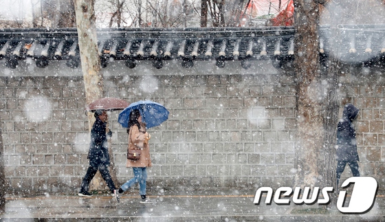 19日在首爾市廳附近，市民們冒雪行走。