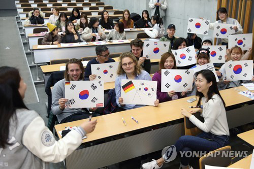 資料圖片：2月27日，在首爾明知大學人文校區，外國人留學生手繪韓國國旗。（韓聯社/明知大學供圖）