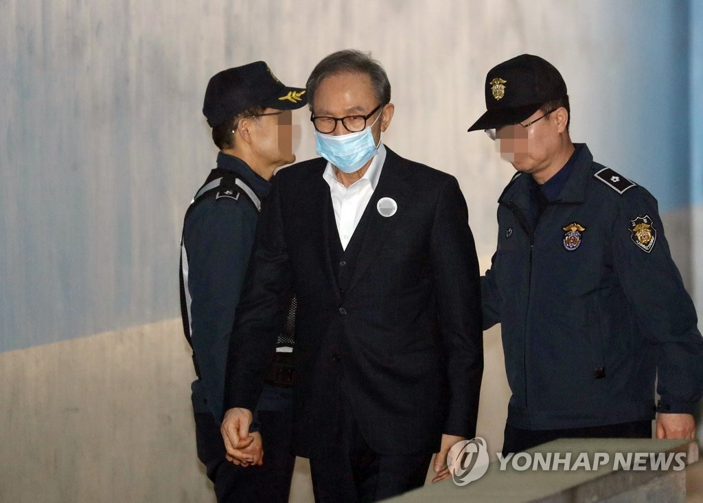 6日上午，李明博從押送車上下來，前往首爾高等法院接受保釋與否的判決。