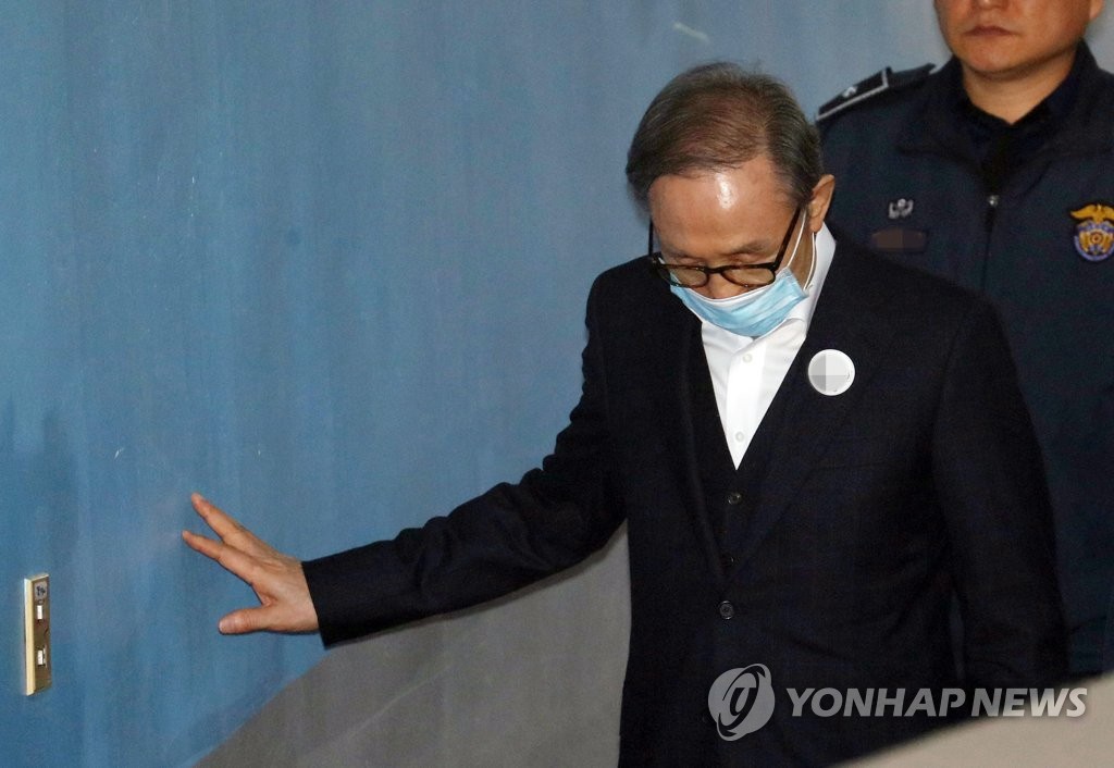 6日上午，李明博從押送車上下來，前往首爾高等法院接受保釋與否的判決。