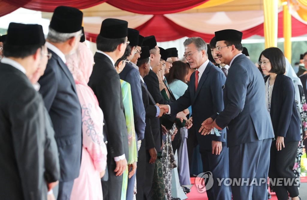 3月13日上午，馬來西亞最高元首阿卜杜拉在吉隆坡議會廣場舉行隆重儀式，熱烈歡迎韓國總統文在寅對馬來西亞進行國事訪問。這是文在寅（右三）與馬來西亞政府內閣成員一一握手。