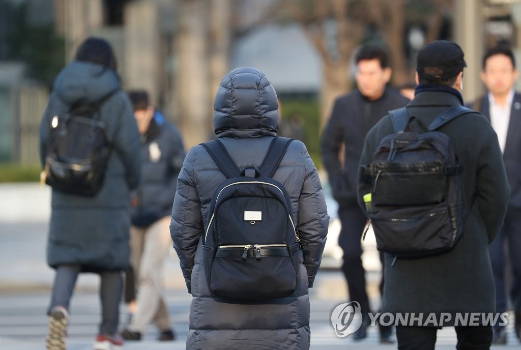今日早晨，首爾市民上班出行前把剛剛脫下的厚外套重新裹緊。