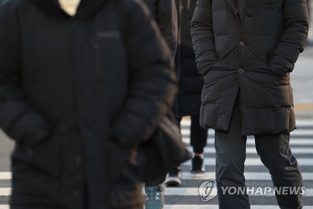 今日早晨，首爾市民上班出行前把剛剛脫下的厚外套重新裹緊。