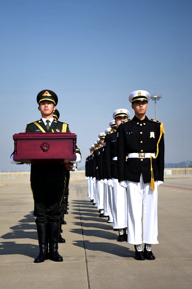 4月3日，在韓國仁川國際機場，韓方（右）向中方禮兵移交中國人民志願軍烈士遺骸。夏雪攝