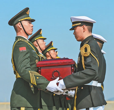4月3日，在韩国仁川国际机场，韩方礼兵（右）向中方礼兵交接中国人民志愿军烈士遗骸。