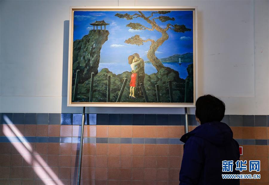 4月2日，在韓國首爾，一名參觀者在展覽現場欣賞一副名為“擁抱”的油畫。 新華社記者 王婧嬙 攝