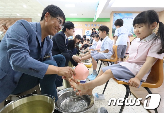 5月15日，在大邱市永新小學，老師給學生洗腳。（圖片來源：news1）
