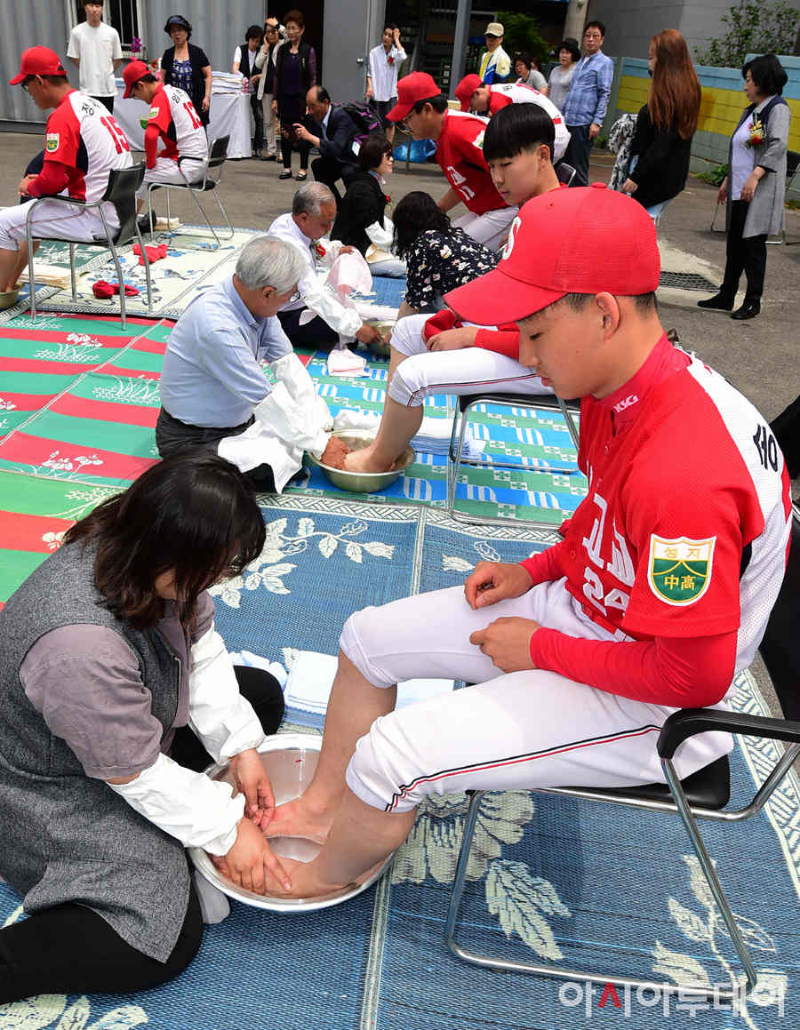 5月15日，在首爾市聖地高中，老師坐在地上為學生親自洗腳。（圖片來源：今日亞洲）