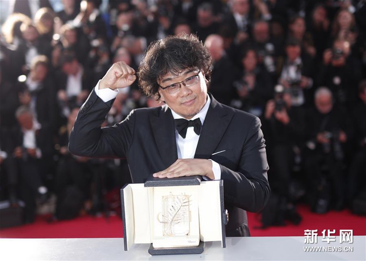 5月25日，在法國戛納，韓國導演奉俊昊展示金棕櫚獎杯。新華社/歐新