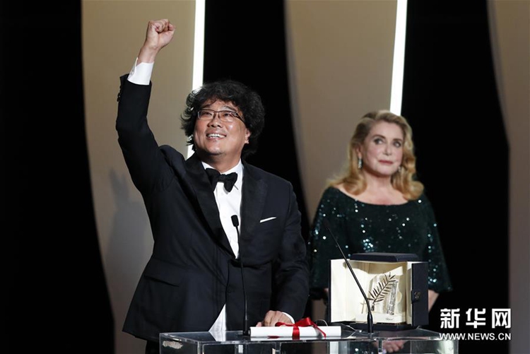 5月25日，在法国戛纳，韩国导演奉俊昊（左）庆祝获得金棕榈奖。新华社/欧新