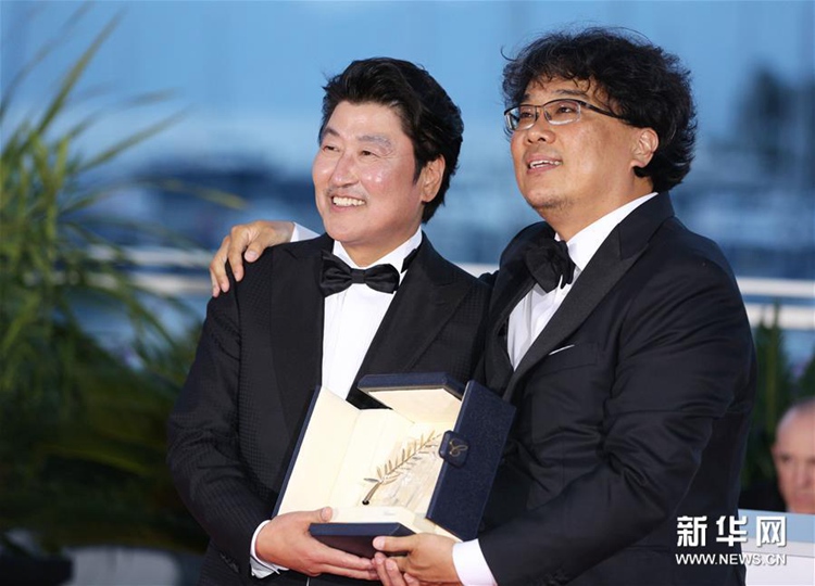 5月25日，在法國戛納，韓國導演奉俊昊（右）與演員宋康昊手捧金棕櫚獎杯出席拍照式。新華社記者 高靜 攝