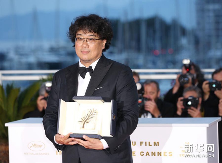5月25日，在法國戛納，韓國導演奉俊昊手捧金棕櫚獎杯出席拍照式。新華社記者 高靜 攝