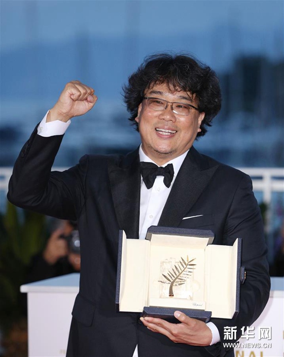 5月25日，在法國戛納，韓國導演奉俊昊手捧金棕櫚獎杯出席拍照式。新華社記者 高靜 攝