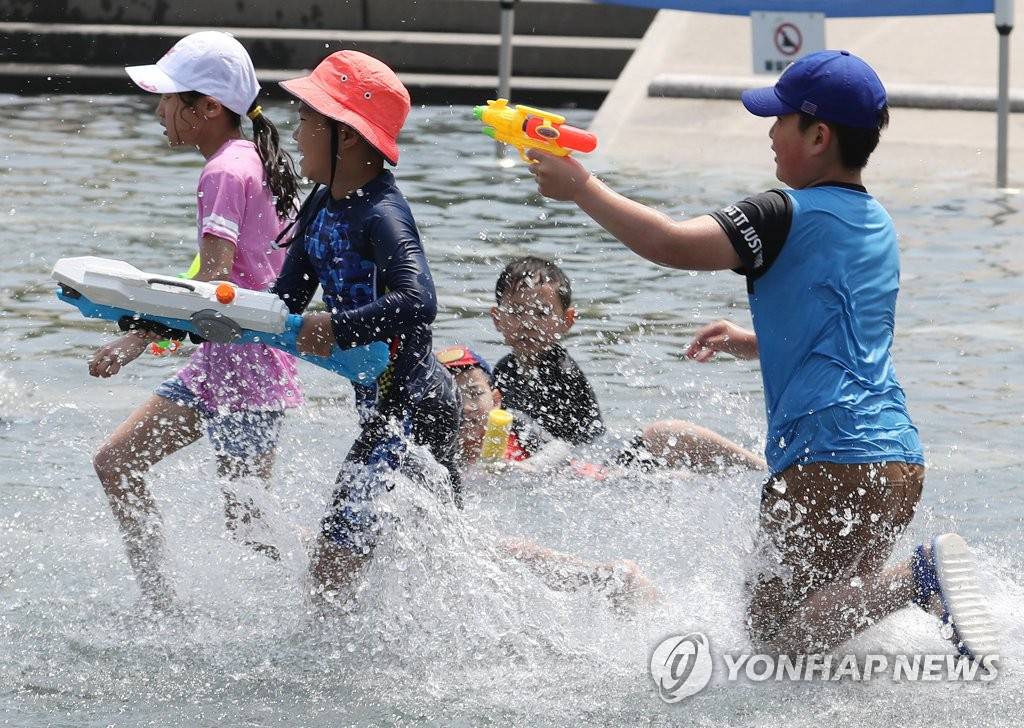 6月2日，在首爾汝矣島水光廣場，孩子們在玩水槍。