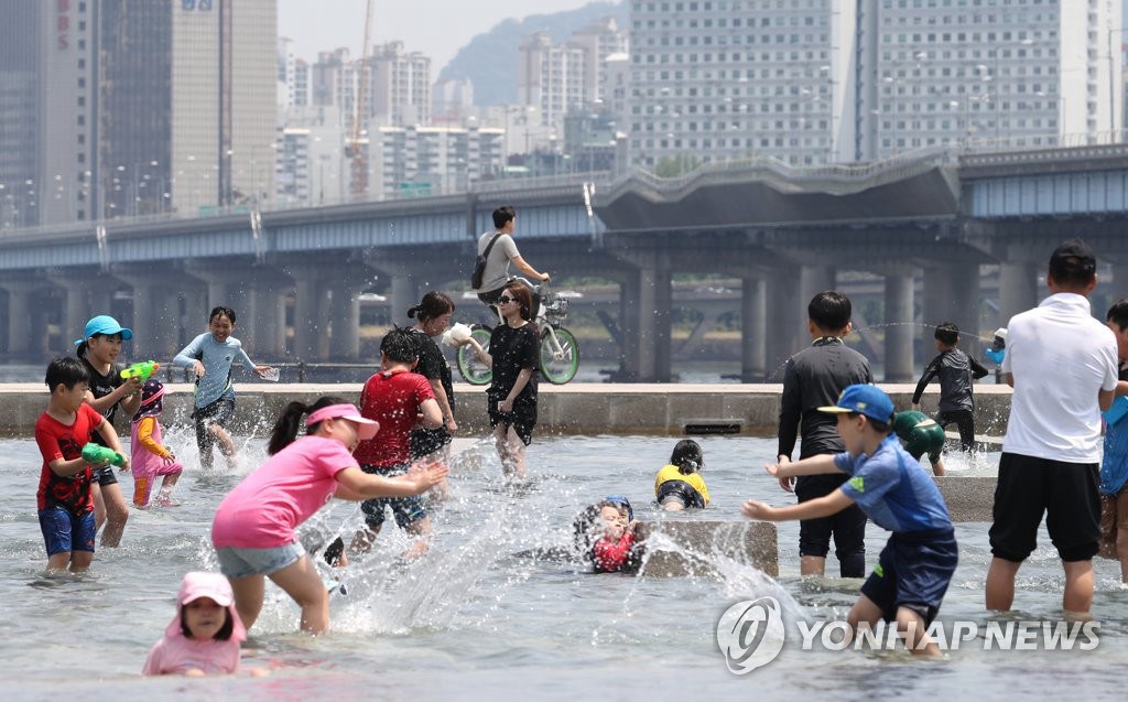 6月2日，在首爾汝矣島水光廣場，一群孩子在戲水打鬧。