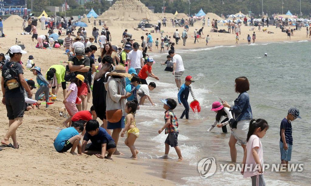 6月2日，在釜山海雲台海水浴場，游客帶著子女來到此地消暑納涼。