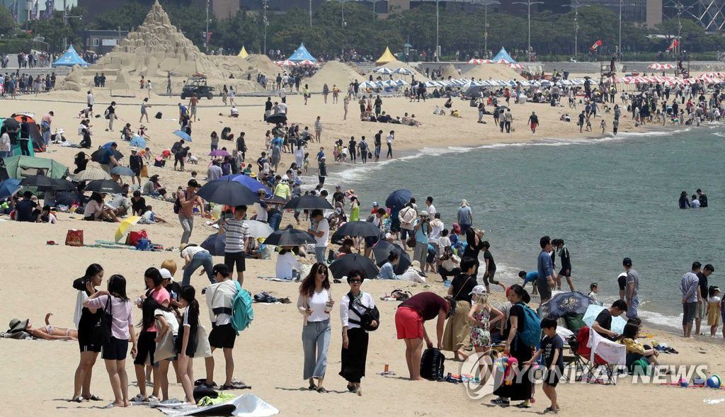 6月2日，在釜山海雲台海水浴場，游客帶著子女來到此地消暑納涼。