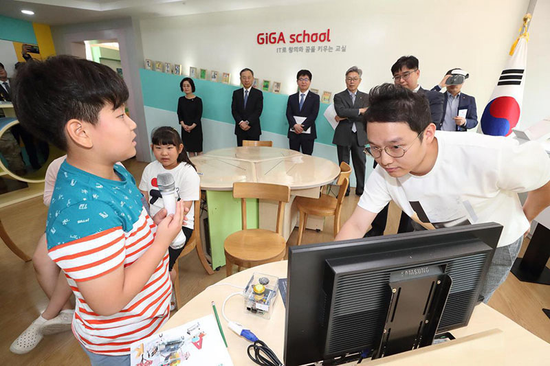 圖為韓國京畿道大成洞村大成洞小學的學生在配有增強現實設備的教室學習體驗。牆上用韓語寫著“用IT技術培育創意和夢想的教室”。（照片由韓國電信公司提供）