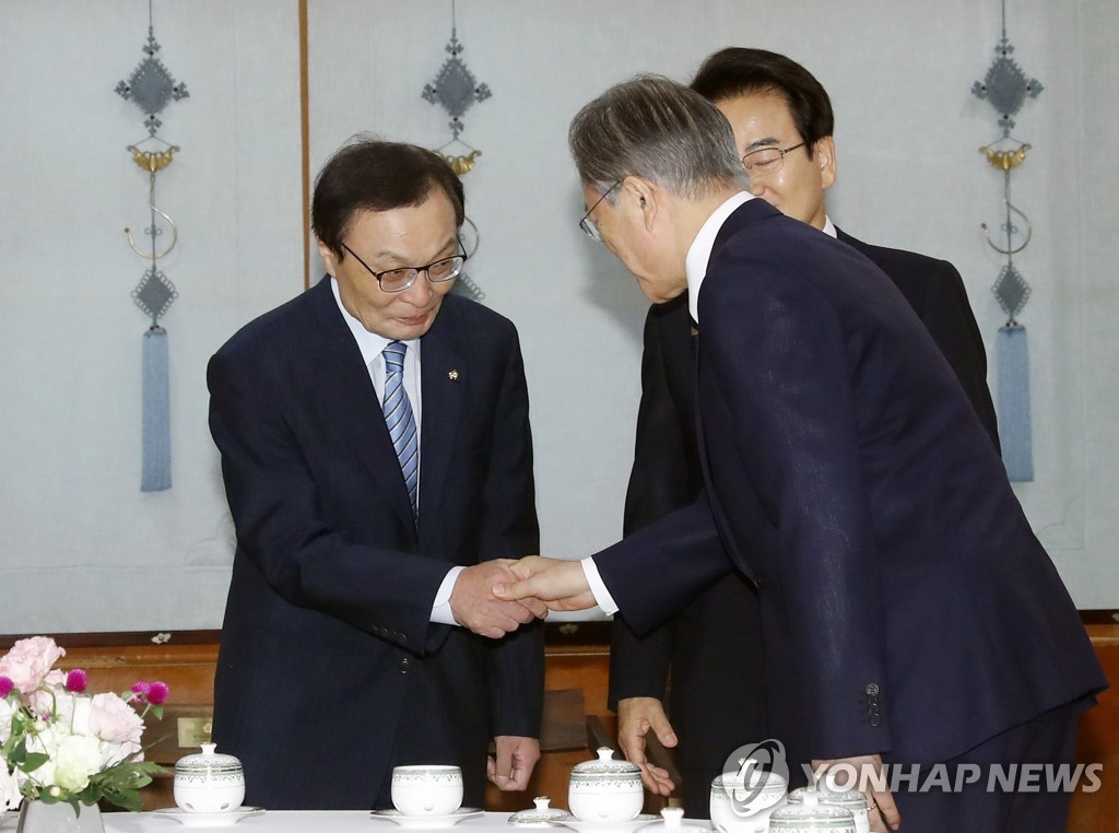 文在寅與執政黨共同民主黨黨首李海瓚握手。