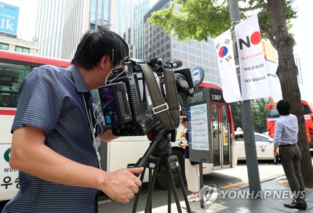 6日上午，在首尔市中区南大门路，日本媒体在拍摄写有No （BOYCOTT）Japan：不去日本，抵制日货”标语的条幅。（图片来源：韩联社）