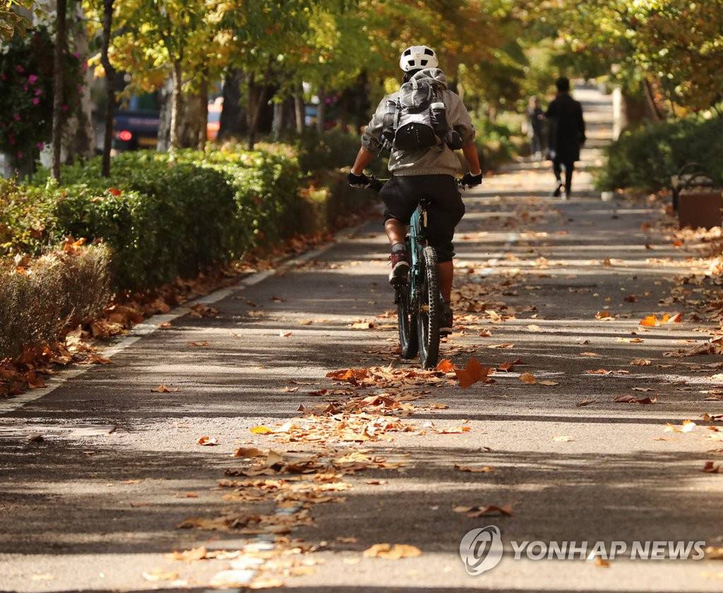 4日在首爾龍山區梨泰院路上，一位韓國市民騎著單車，感受陣陣秋風。
