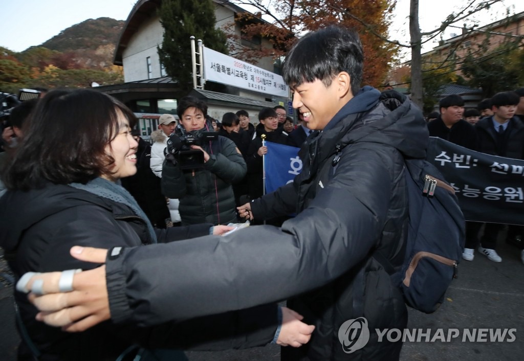 14日上午，首爾永登浦區汝矣島女子高中的考生與老師擁抱。