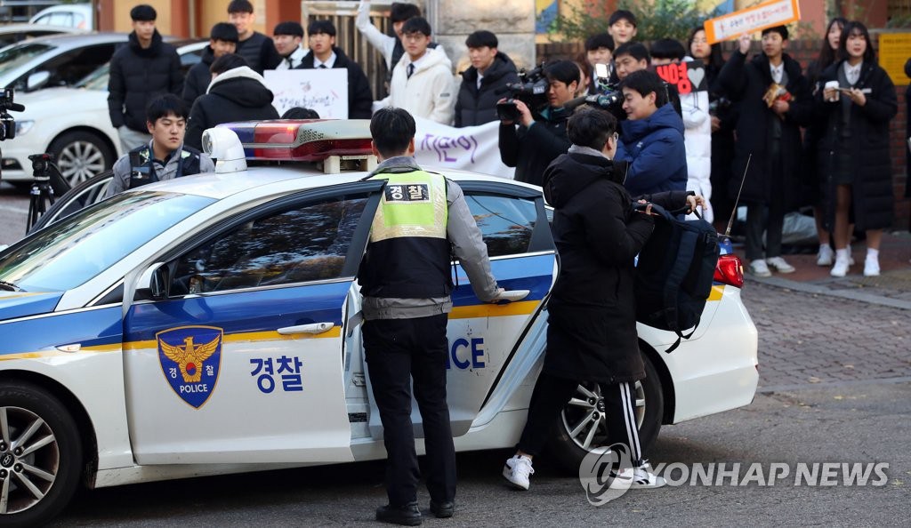 14日上午，首爾永登浦區汝矣島高中門口前，一名高三考生乘坐警車抵達考場。 