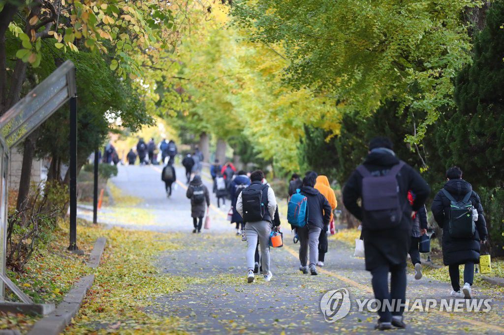 14日上午，首爾江南區的京畿高中的考生們向考場走去。