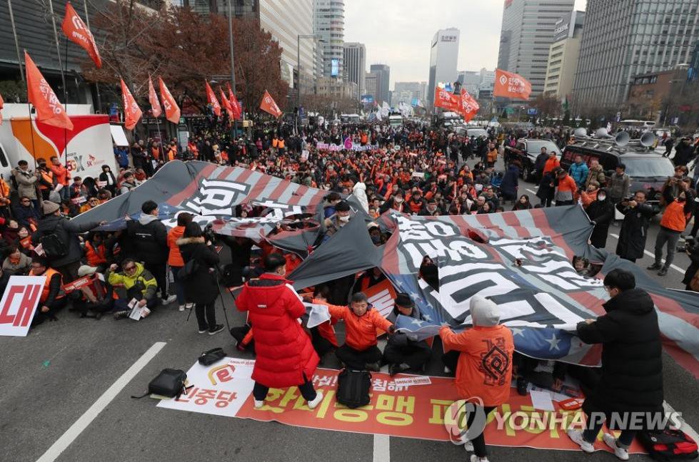 11月30日，韓國民眾在美國大使館前撕毀星條旗。（韓聯社）