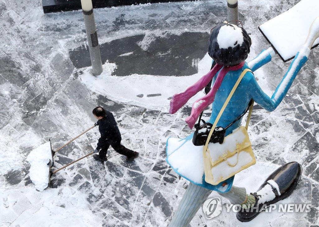 17日上午，首爾鐘路某建筑前，工作人員夜間清理積雪。